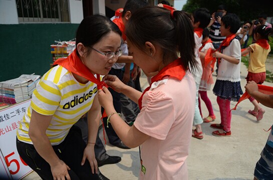 捐贈儀式上，孩子們?yōu)閻坌奶焓瓜瞪霞t領(lǐng)巾