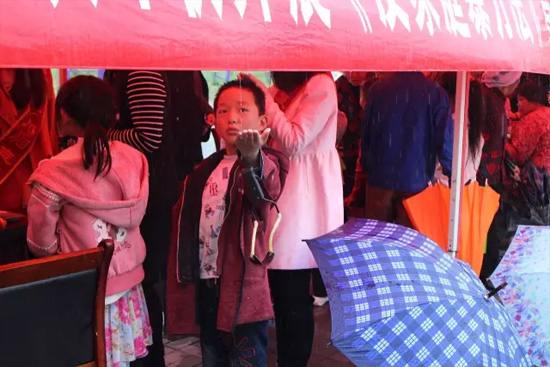 因為雨下的太大，小男孩玩起了接水游戲。