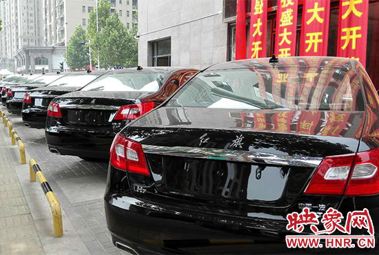 路邊一棟樓上懸掛著二三十條紅色條幅，全部是祝賀一家公司開業(yè)的。