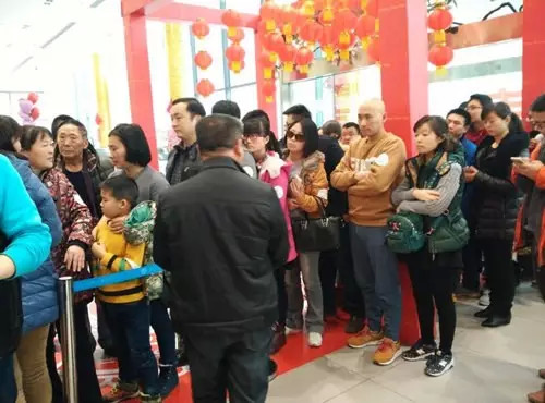 排隊(duì)領(lǐng)年貨，一家老小齊上陣。