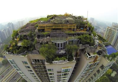 　　昨日，身穿橘黃色馬甲的工作人員在人濟山莊樓頂拆除違章建筑。新京報記者 吳江 攝