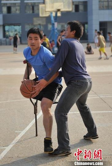 圖為拄著拐杖的瞿詩濤和同學(xué)搶球。劉占昆攝