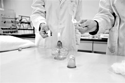 實驗人員操作的燃燒檢測法中，真蠶絲離開火焰就熄滅(左)。