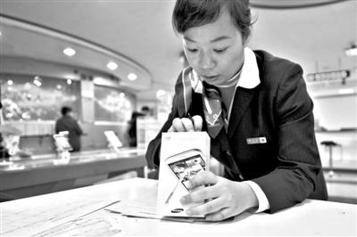 11月6日，北京移動西直門營業(yè)廳的工作人員在為顧客購買的4G手機登記。新華社發(fā)