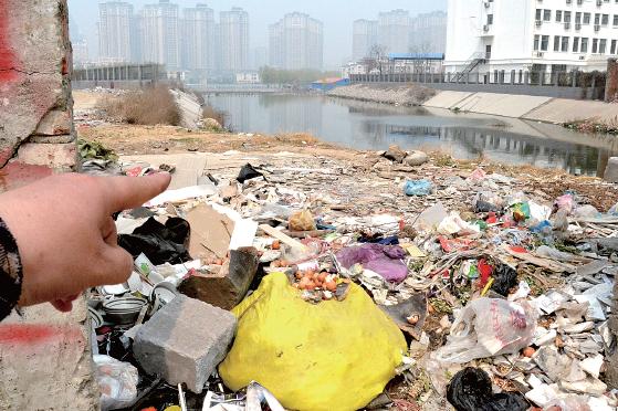 金水河長江路橋下河水發(fā)臭，水邊堆放眾多垃圾