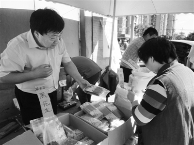 昨日，河南企業(yè)家劉春喜在京“練攤”，為顧客挑選綠豆。新京報(bào)記者 張玉學(xué) 攝