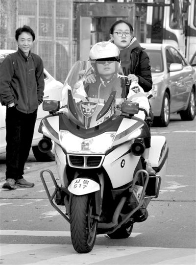 7日，首爾，警察將一名考生送抵考場。新華社發(fā)