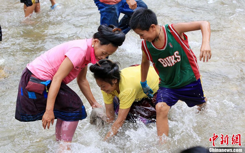 7月9日，村民在小河里摸魚搶魚。譚凱興 攝