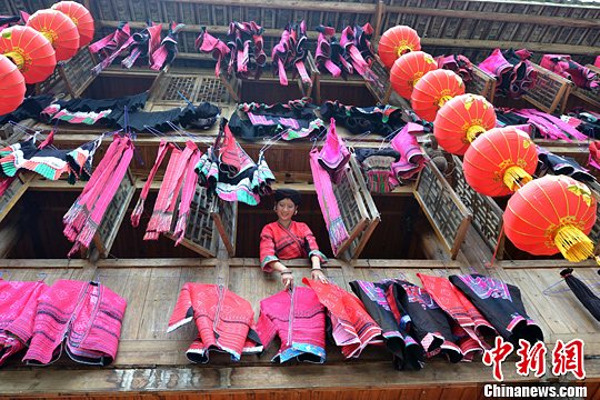 圖為紅瑤姑娘把紅衣晾曬出來(lái)。中新社發(fā) 韋吉陽(yáng) 攝