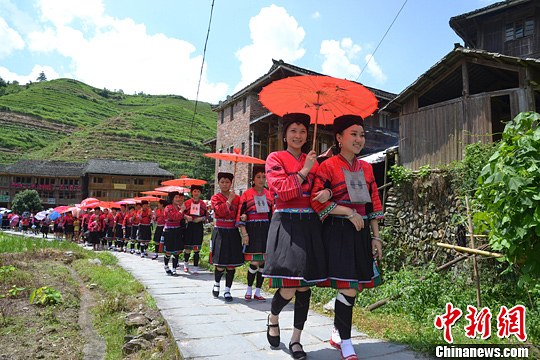 圖為新娘身著瑤族盛裝在伴娘和親友的陪伴下“出嫁”。中新社發(fā) 韋吉陽(yáng) 攝