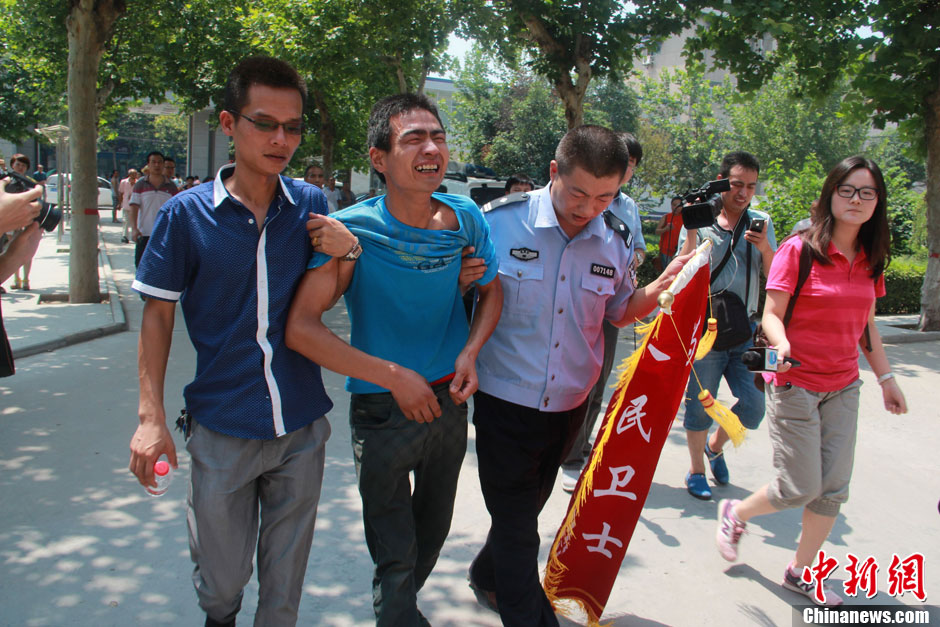 圖為獲救嬰兒父親情緒一度失控，當(dāng)?shù)鼐焦ぷ魅藛T對其進(jìn)行攙扶。張一辰 攝