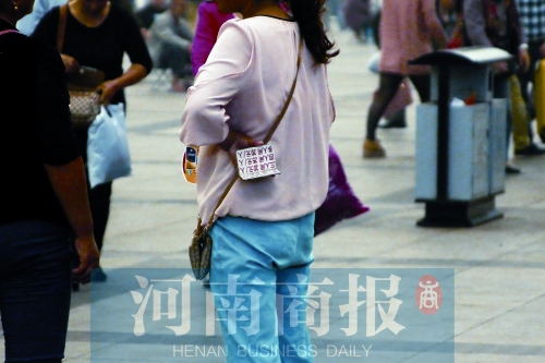 火車(chē)站廣場(chǎng)，一女子拿著寫(xiě)有不同房型價(jià)位的卡片在拉客，不少市民抱怨，受過(guò)此類(lèi)“騷擾”