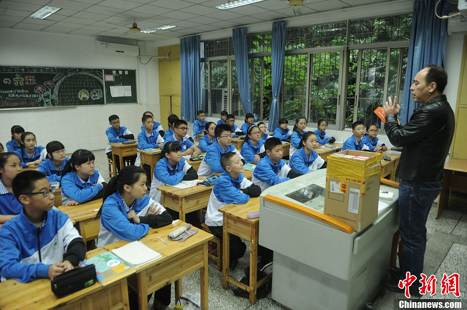 圖為老師正在向同學(xué)們講解用非智能手機(jī)對(duì)他們的好處。