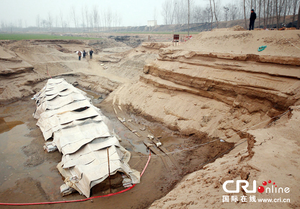 2014年1月6日，河南洛陽古沉船發(fā)掘現(xiàn)場，近日有雨雪天，考古人員給古沉船披上一層“雨衣”。