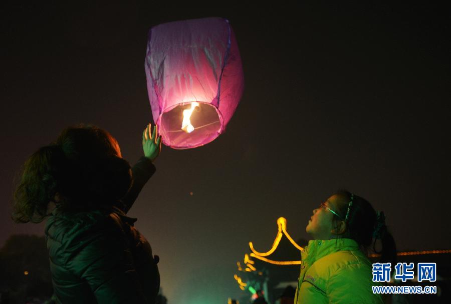 　1月30日，游客在江蘇省鎮(zhèn)江市金山公園門口放飛孔明燈。