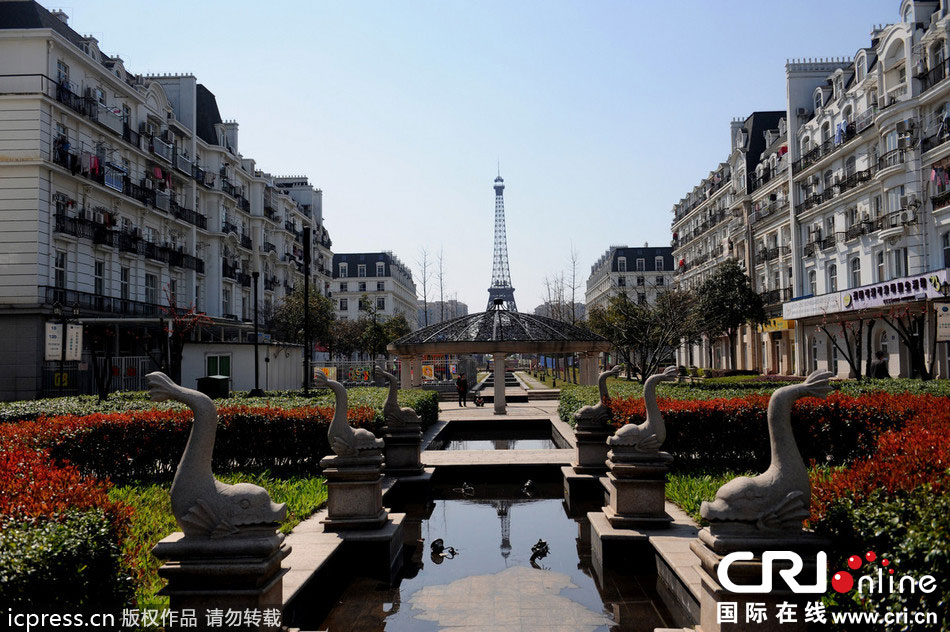 　2014年3月21日，杭州天都城，農(nóng)民在山寨埃菲爾鐵塔下耕作。圖片來(lái)源：東方IC