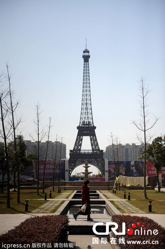 　2014年3月21日，杭州天都城，農(nóng)民在山寨埃菲爾鐵塔下耕作。圖片來(lái)源：東方IC