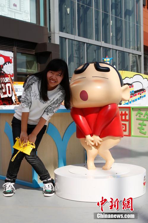 4月22日，游客與蠟筆小新合影。“蠟筆小新25周年紀(jì)念特展”日前在北京開(kāi)展，吸引了不少市民游客。