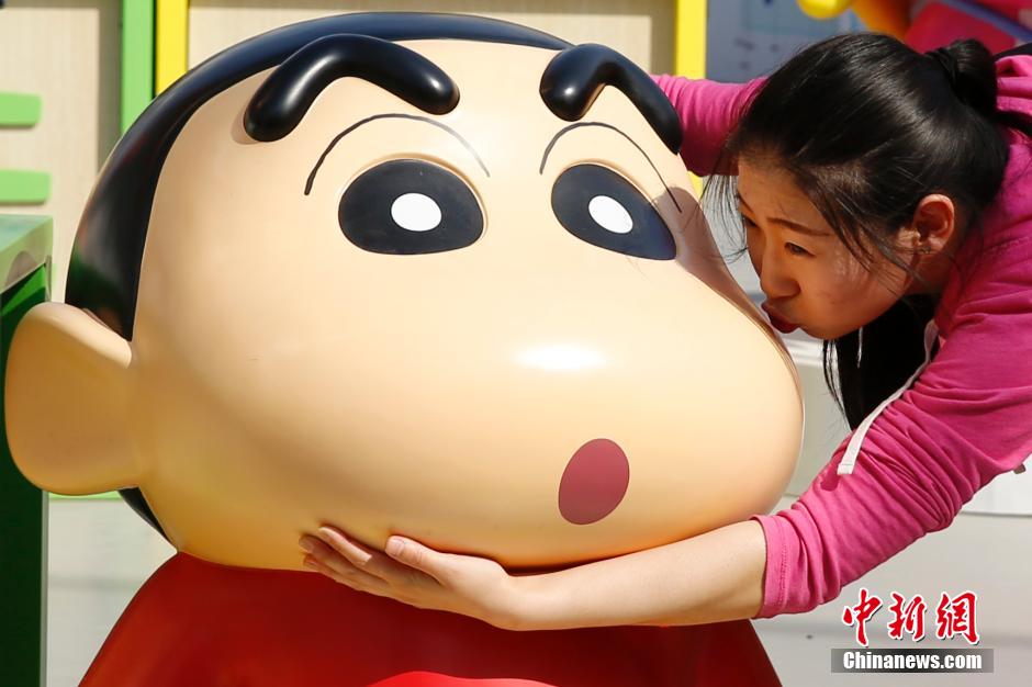 4月22日，游客與蠟筆小新合影?！跋灩P小新25周年紀(jì)念特展”日前在北京開(kāi)展，吸引了不少市民游客。