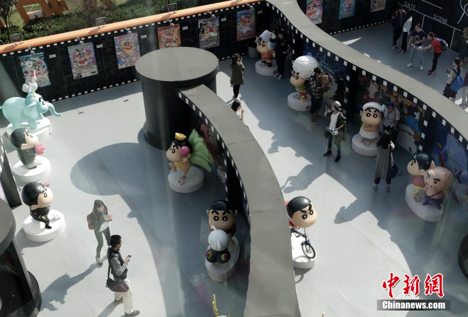 4月22日，游客與蠟筆小新合影?！跋灩P小新25周年紀(jì)念特展”日前在北京開(kāi)展，吸引了不少市民游客。