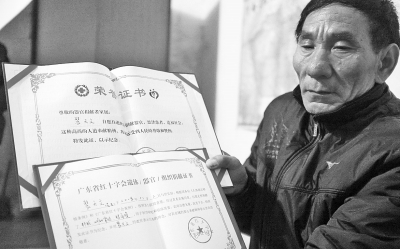 裴富才老人拿著有關(guān)部門(mén)頒發(fā)的證書(shū)