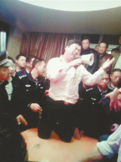 　4月19日，泰州市濱江工業(yè)園區(qū)管委會(huì)招待中心，一男子跪在酒桌上喊話求饒。李根 攝