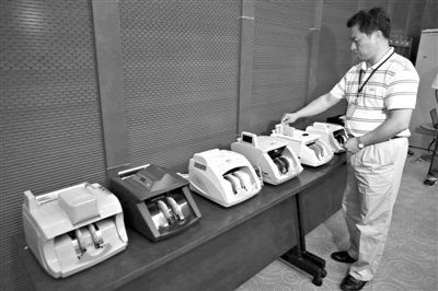 昨日，央行工作人員用各種驗(yàn)鈔機(jī)對(duì)C1F9假幣進(jìn)行測(cè)試，機(jī)器均能及時(shí)作出異常報(bào)警反應(yīng)。新京報(bào)記者 浦