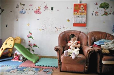 6月14日，未婚媽媽于軍的家里。女兒悅悅抱著兔子玩偶，在聽媽媽手機上的兒歌，這個4歲女孩喜歡兔子。