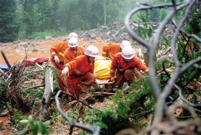 昨日，消防隊員在四川省都江堰市中興鎮(zhèn)三溪村滑坡現(xiàn)場運送遇難者遺體。新華社記者 薛玉斌 攝