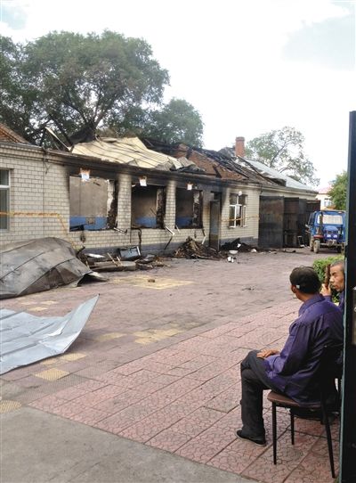 7月27日，海倫聯(lián)合敬老院內(nèi)，幾名老人看著對(duì)面被燒毀的特護(hù)病房。新京報(bào)記者 涂重航 攝