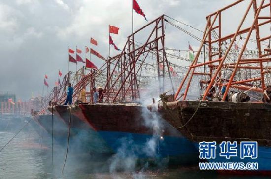 2013年8月1日 南海開漁日 臨高迎新港 8月1日，海南省臨高縣漁民在船上鳴放鞭炮慶祝武蓮港開港。