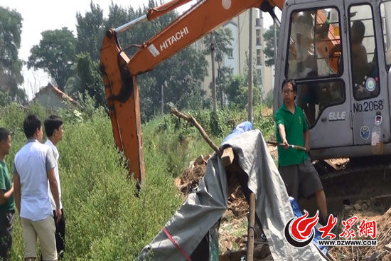 陳寶成手持自制刀斧守在挖掘機旁阻止便衣民警靠前。駕駛室內(nèi)，張朋珂正向受害人郭曉剛身上澆汽油。（視頻截圖）