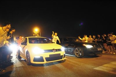 8月24日晚，東壩中街飆車現(xiàn)場，兩輛車并排等待出發(fā)指令，旁邊許多愛好者前來觀看比賽。新京報(bào)記者