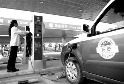 9月11日，懷柔區(qū)，電動(dòng)出租車司機(jī)正在為車輛充電。