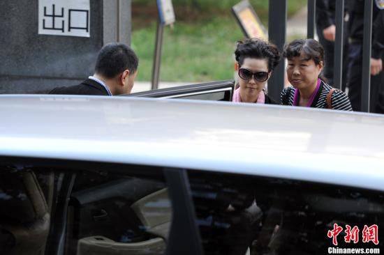 圖為宣判結束后夢鴿面無表情走出海淀法院，乘車離開。