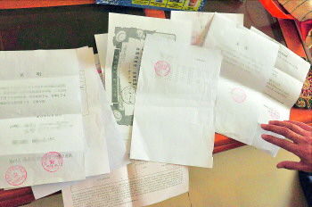 60歲的市民仇先生為了辦理公證所需的這些證明材料,半個(gè)月時(shí)間里跑了30多趟腿。記者　李萌博　攝