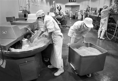 昨日，位于順義李遂開發(fā)區(qū)的慶豐包子鋪配送中心生產(chǎn)車間，工人們正在斬拌胡蘿卜餡料。