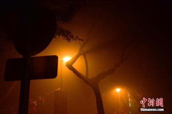 1月31日凌晨，市民行走在煙霧繚繞的南京街頭。當天是農歷馬年正月初一，南京有限開禁燃放煙花爆竹正逢下霧天，空氣的不流通致使煙花爆竹燃燒后產生的顆粒物不能及時散開，造成整座城市煙霧繚繞。據(jù)當?shù)丨h(huán)保部門發(fā)布的信息顯示，空氣質量屬重度污染。中新社發(fā) 泱波 攝