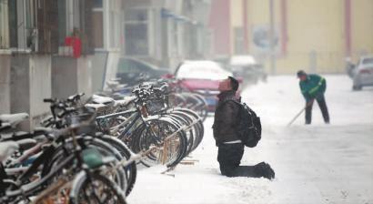 小伙子跪在樓前，一直抬頭看著樓上。 孫立國(guó)/攝