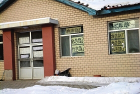 伊春市帶嶺區(qū)一排破舊的平房，房間窗戶上貼滿了“我告饒了”的字樣。