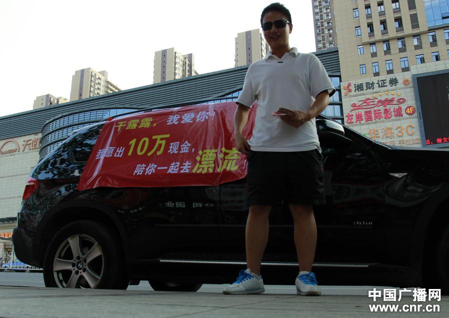 湖南婁底“寶馬男”手捧現(xiàn)金當(dāng)街舉牌示愛(ài)干露露