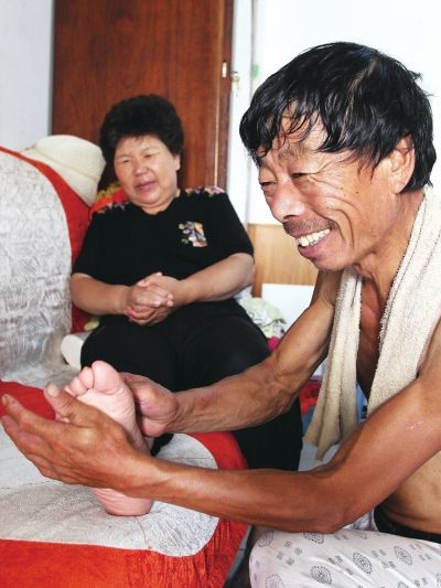 慈成富為老伴按摩。