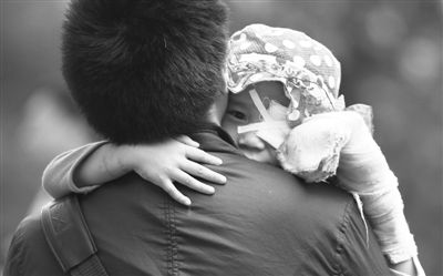 昨日，北京同仁醫(yī)院，被砍傷的彤彤趴在舅舅的肩上。他們剛剛掛完號，正準備回旅館。新京報記者 尹亞飛 攝