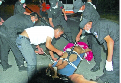 眾人合力將狂犬病發(fā)作的江某控制住。 孫東城 攝