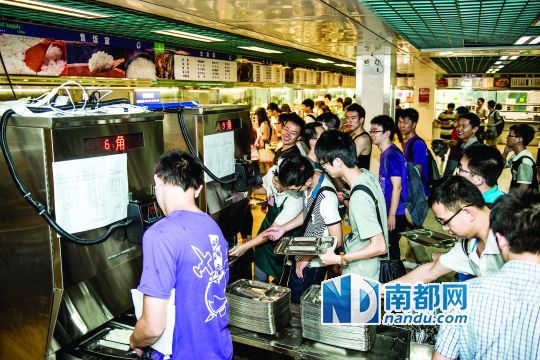 昨日，華南理工大學(xué)一食堂內(nèi)，學(xué)生們正在使用新安裝的自動打飯機(jī)打飯。中新社發(fā)