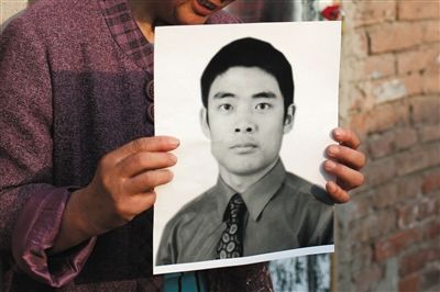 5月19日，朝陽北路，母親捧著張東文的遺像。新京報記者 侯少卿 攝