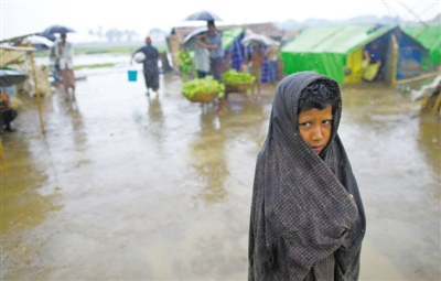 5月14日，緬甸若開邦實兌難民營，羅興亞族難民在雨中行走。熱帶風暴“馬哈森”即將登陸緬甸，這里的難民開始乘船撤離。