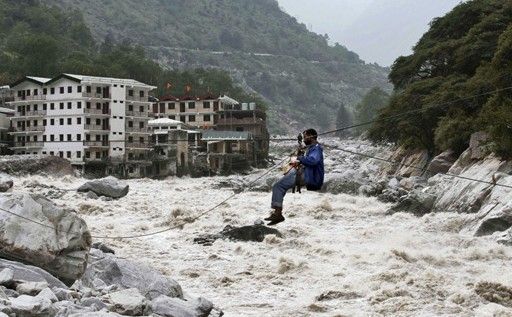 一名印度男子靠繩索渡河。