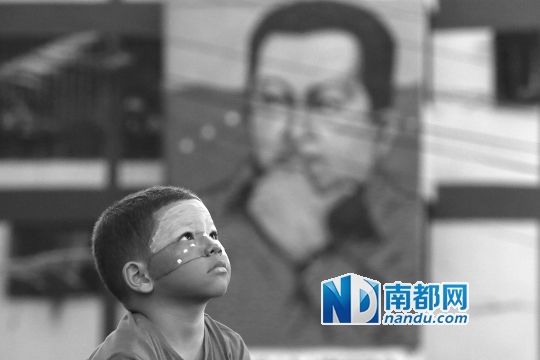 3月5日，一名委內(nèi)瑞拉兒童仰望天空，他身后是查韋斯的陵墓。