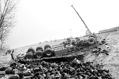 　一輛貨車沖開護欄翻下高速，輪胎散落一旁